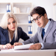 deux personnes travaillent ensemble sur un bureau
